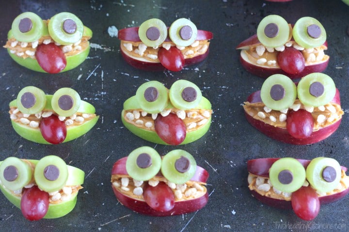 Nine Apple Monsters (with both red and green apples) sitting on a scratched black background.