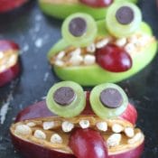Closeup of one monster made from red apples, with two green ones behind.