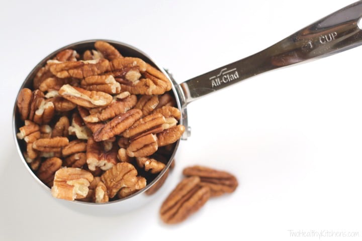 Overhead of raw pecans in measuring cup before being roasted and candied. 