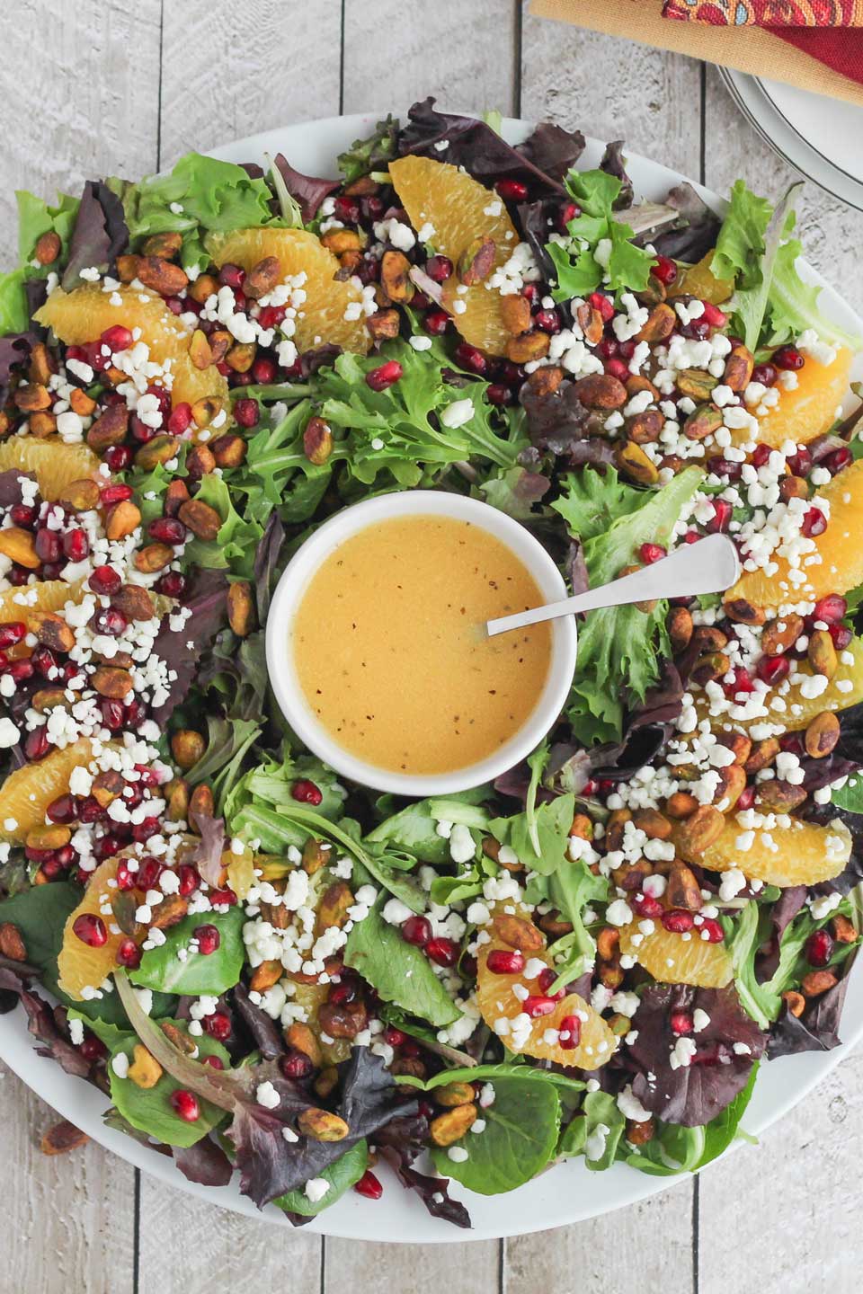 Our easy, beautiful Christmas Salad can even be served as a wreath! A perfect holiday salad, absolutely brimming with goat cheese, pomegranate arils, crunchy pistachios, and juicy orange slices – what a showstopper!