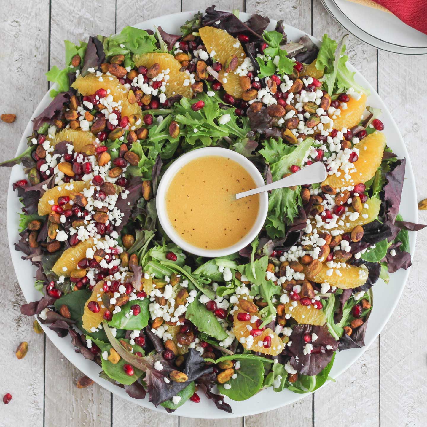 Our easy, beautiful Christmas Salad can even be served as a wreath! So delicious with pistachios, pomegranate, oranges and goat cheese with a light citrus-champagne vinaigrette!