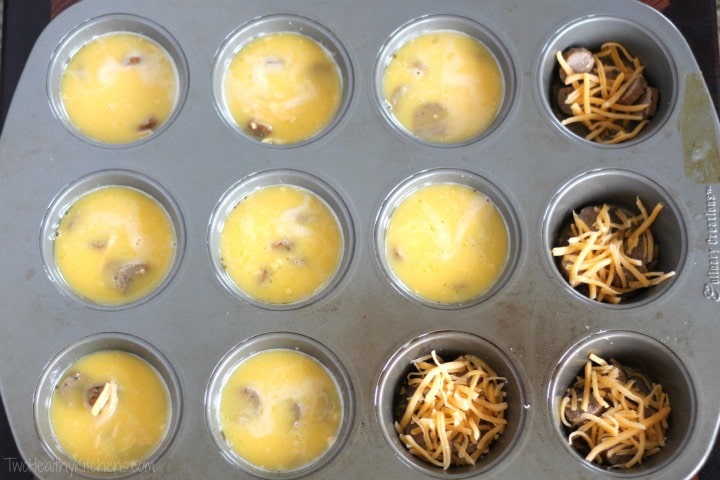 Overhead of muffin tin, 4 holes filled with only sausage and cheese, and the rest topped off with egg.