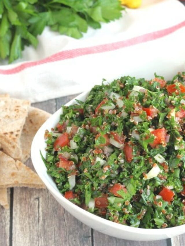 Closeup side view of tabouli piled in serving bowl so you can really see the ingredients' textures and tiny quinoa.