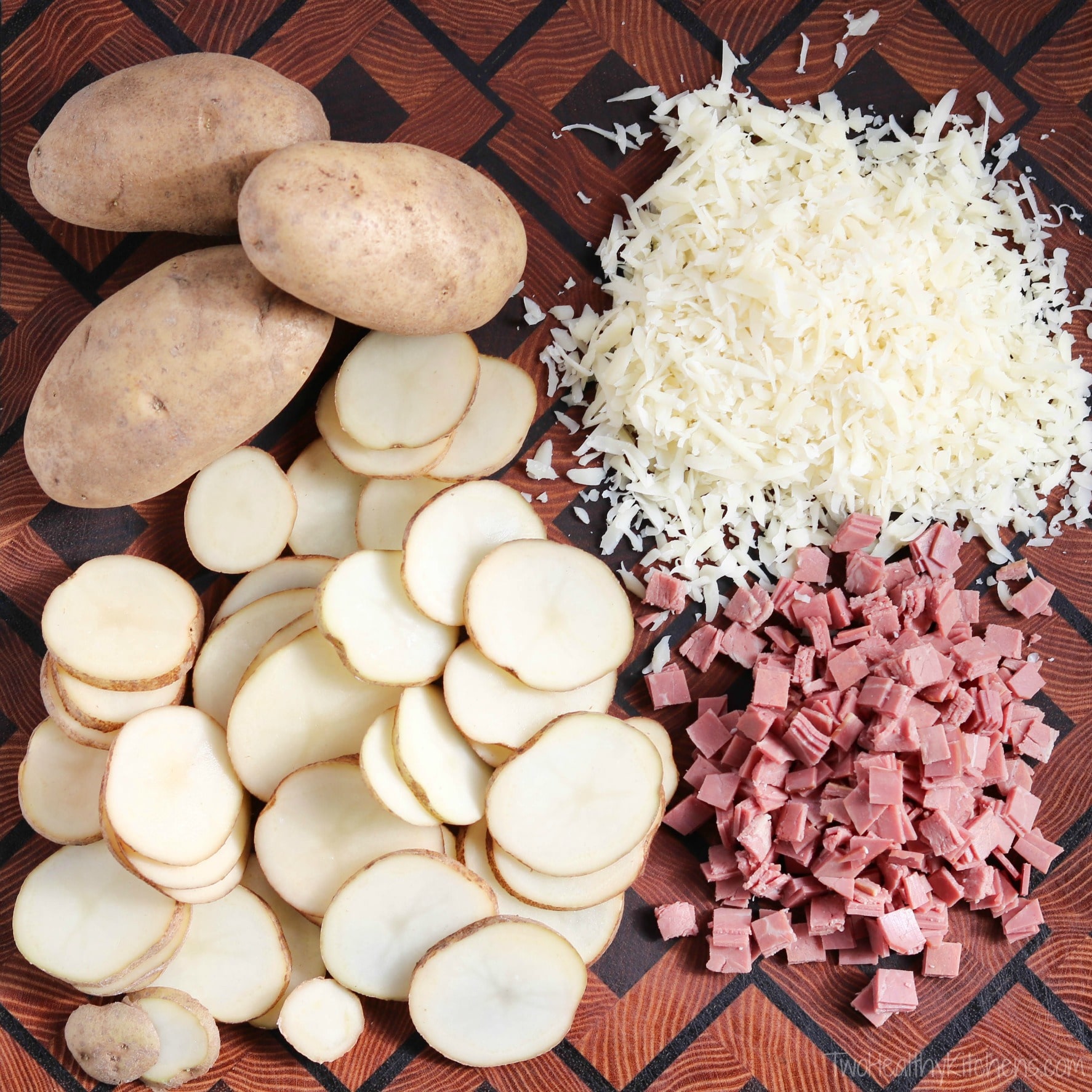 3 whole potatoes, potato slices, chopped corned beef and shredded Swiss cheese in piles on patterned wood cutting board.