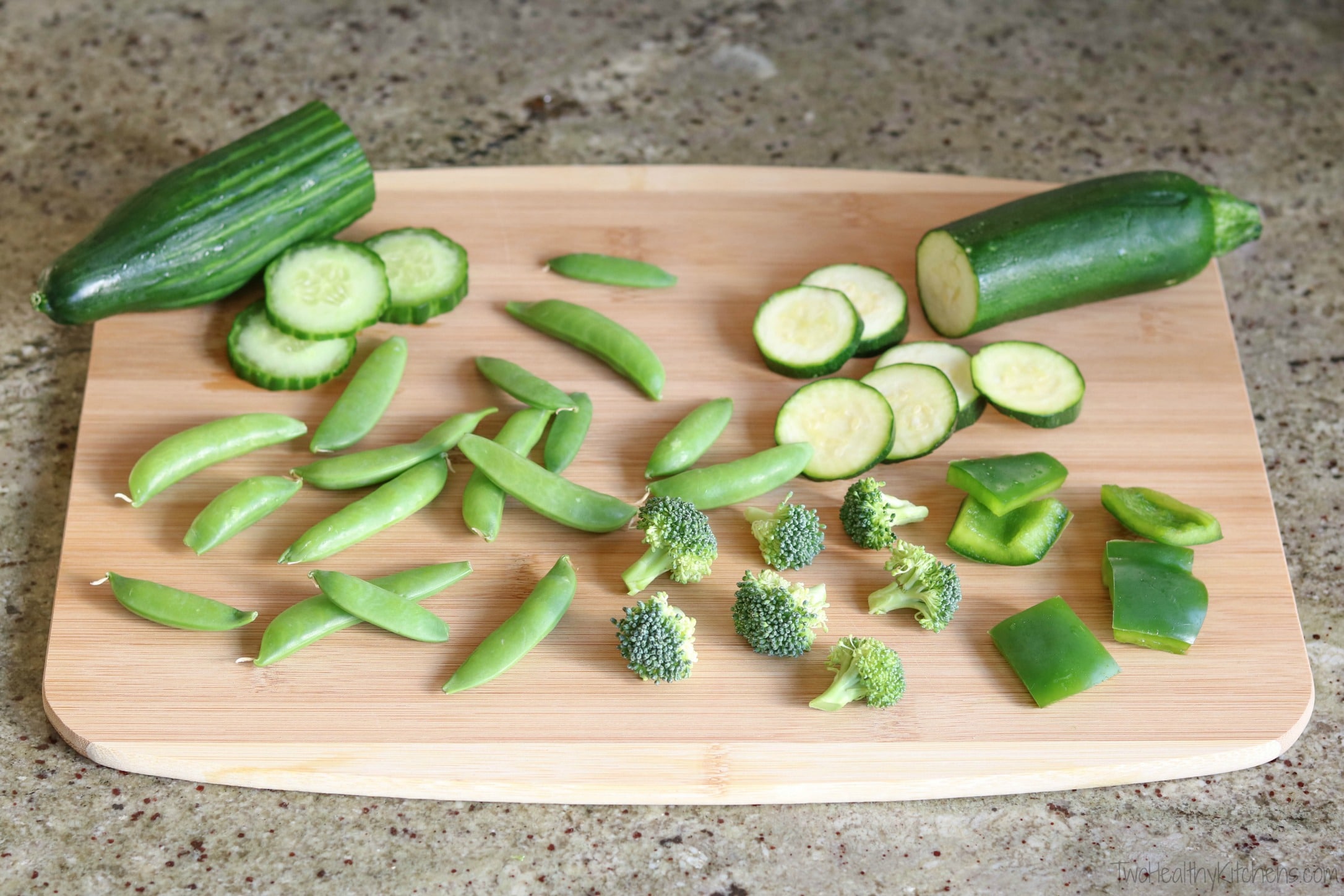 Green veggies arrayed on bamboo cutting board, ready to be added to skewers.