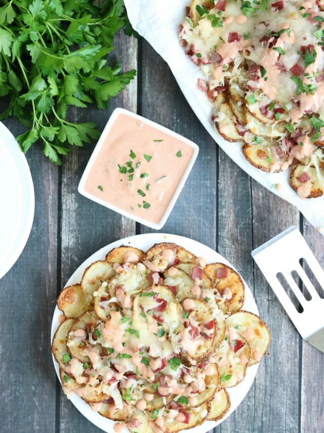 Flatlay scene of one serving taken from serving platter, bowl of sauce, scooper and fresh parsley.