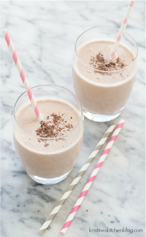Two smoothies in clear glasses with pink and gray-striped straws.