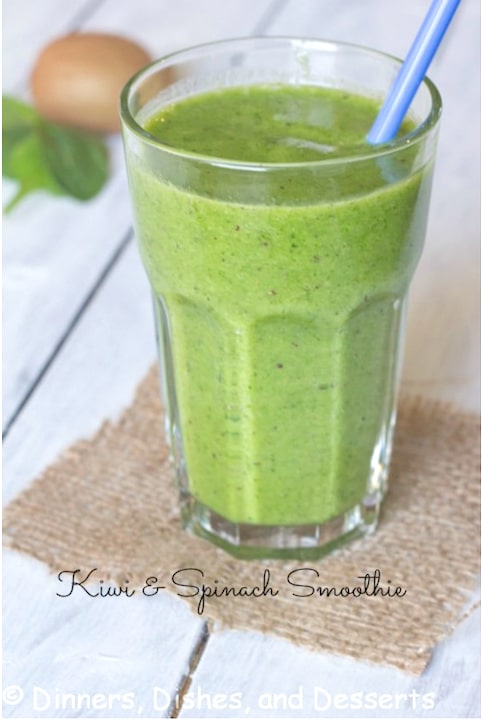 Green smoothie on square of burlap with blue straw.