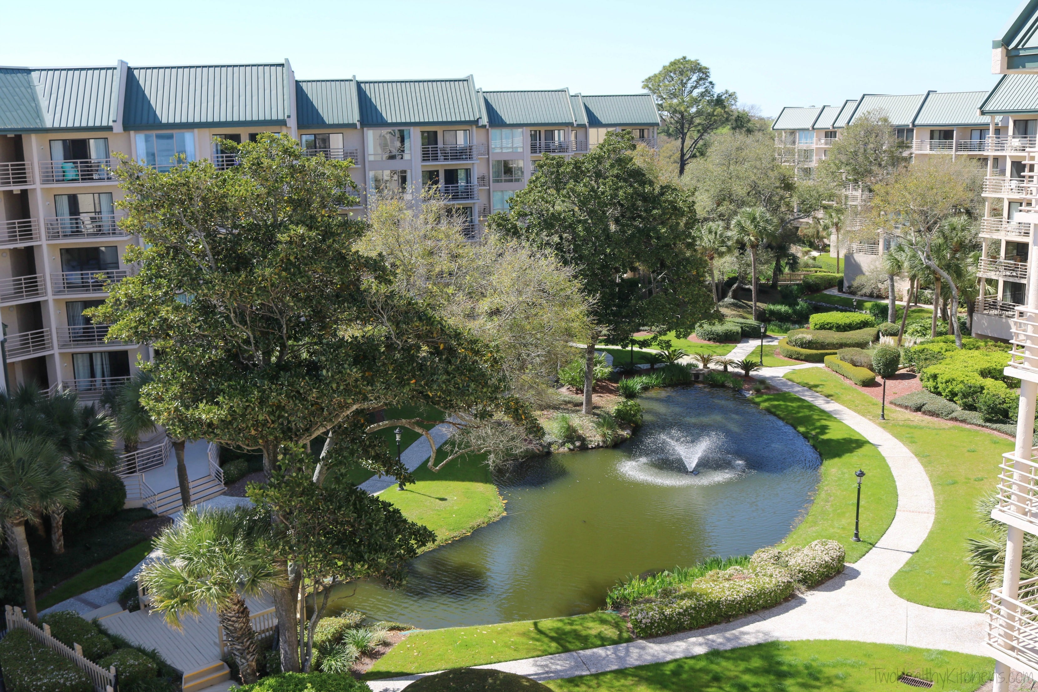 Pond, trees and walkways of interior courtyard at Villamare condos in Hilton Head.