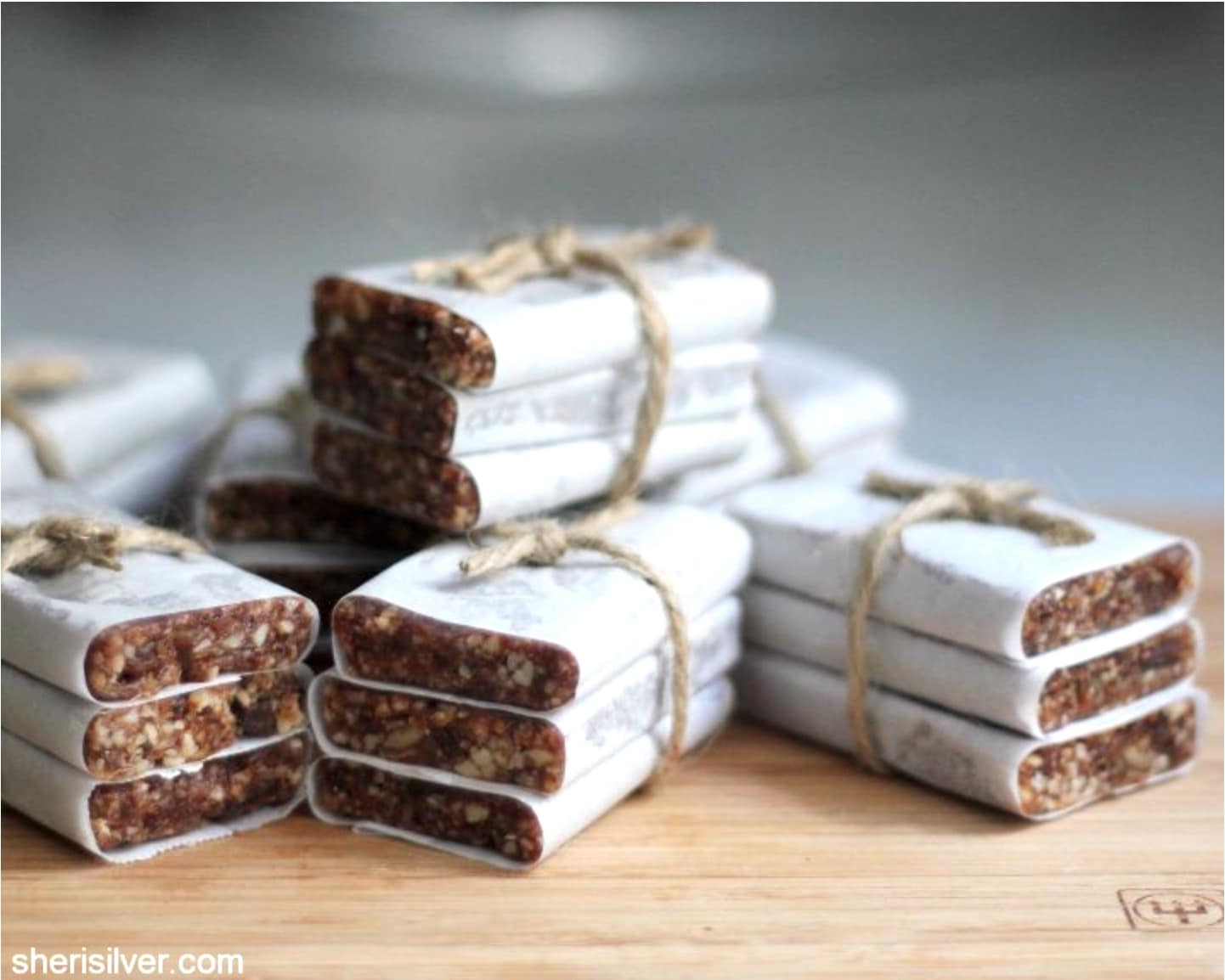 Sets of snack bars, each wrapped in white paper, tied with twine in bunches of three. 