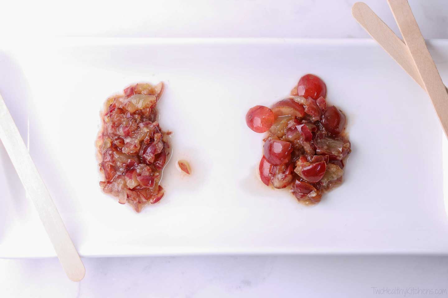 Rectangular white platter with two blobs of pureed red grapes - the right one more chunky - to show optional textures.