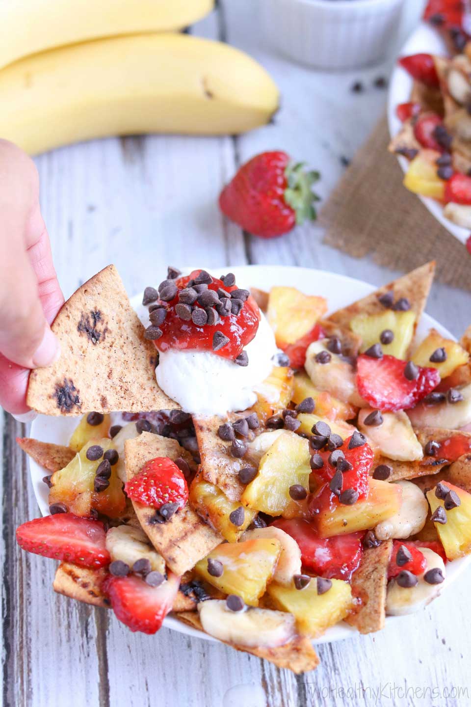 An easy, fun, and surprisingly healthy dessert! This unique dessert nachos recipe has all the flavors of a classic banana split! Crispy, sweetened "nacho chips," caramelized fruit, and a delicious strawberry sauce! Even better with a little scoop of ice cream! A simple yet decadent family favorite! {ad} | www.TwoHealthyKitchens.com
