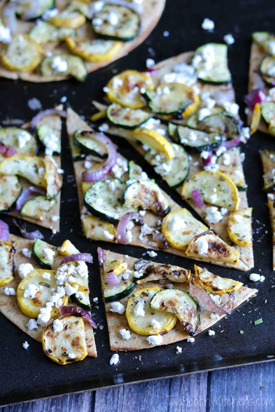 Easy and incredibly flavorful, with just a few simple ingredients! This Grilled Zucchini Flatbread recipe is perfect served as an impressive, hearty appetizer, or combined with a salad for lunch or an easy dinner! If you need zucchini recipes to use up extra zucchini, this quick grilled flatbread recipe is ideal! With creamy goat cheese and grilled vegetables, it’s like a grilled pizza with the crispy cracker-thin crust of a flatbread! A great 30-minute meal! {ad} | www.TwoHealthyKitchens.com