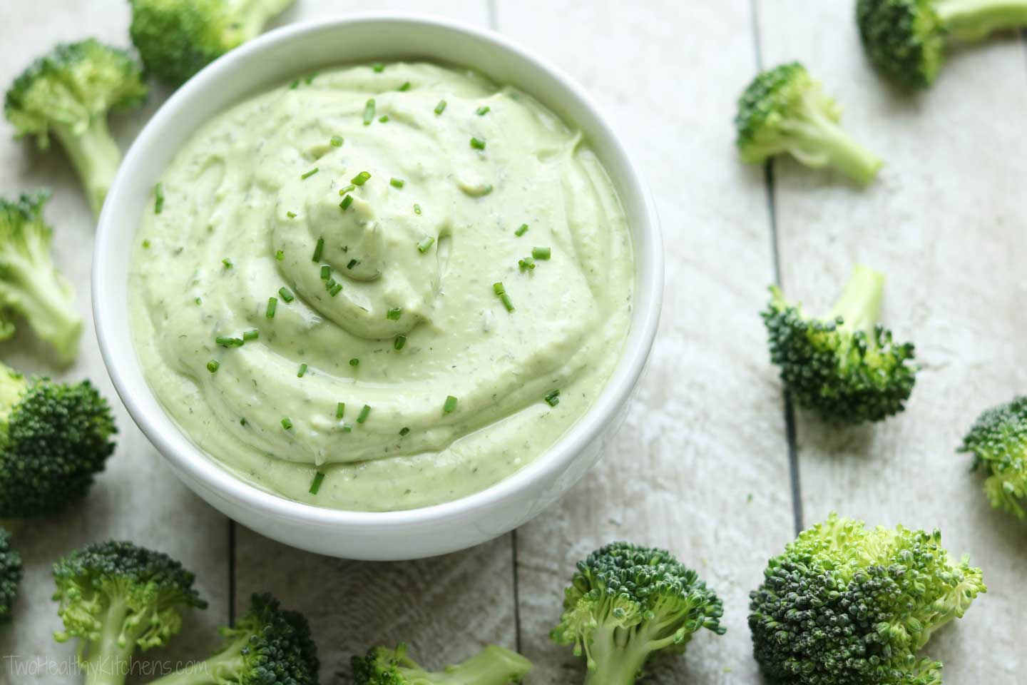 bowl of ranch dip surrounded by scattered broccoli florets