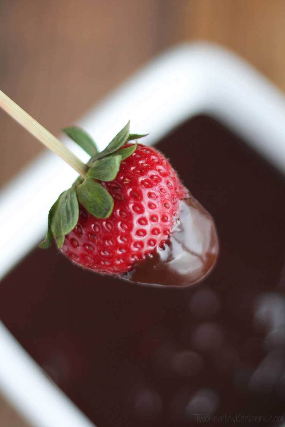 closeup of a skewered strawberry dipped in Chocolate Lava Dip