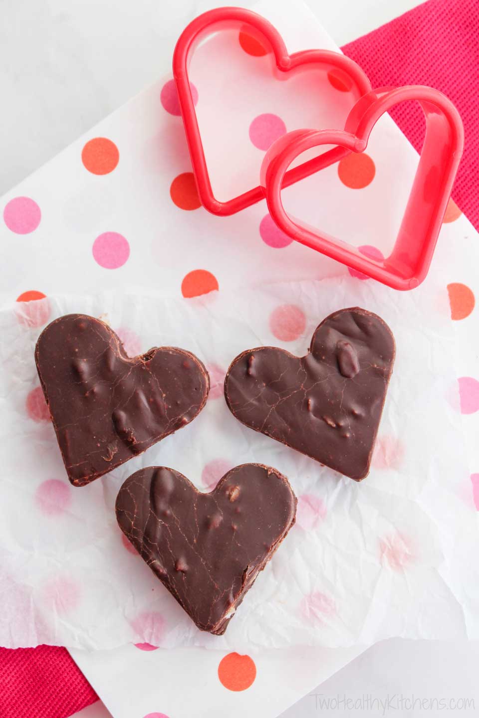 healthier fudge, cut into heart shapes and laying on polka dot paper, with heart-shaped cookie cutters nearby