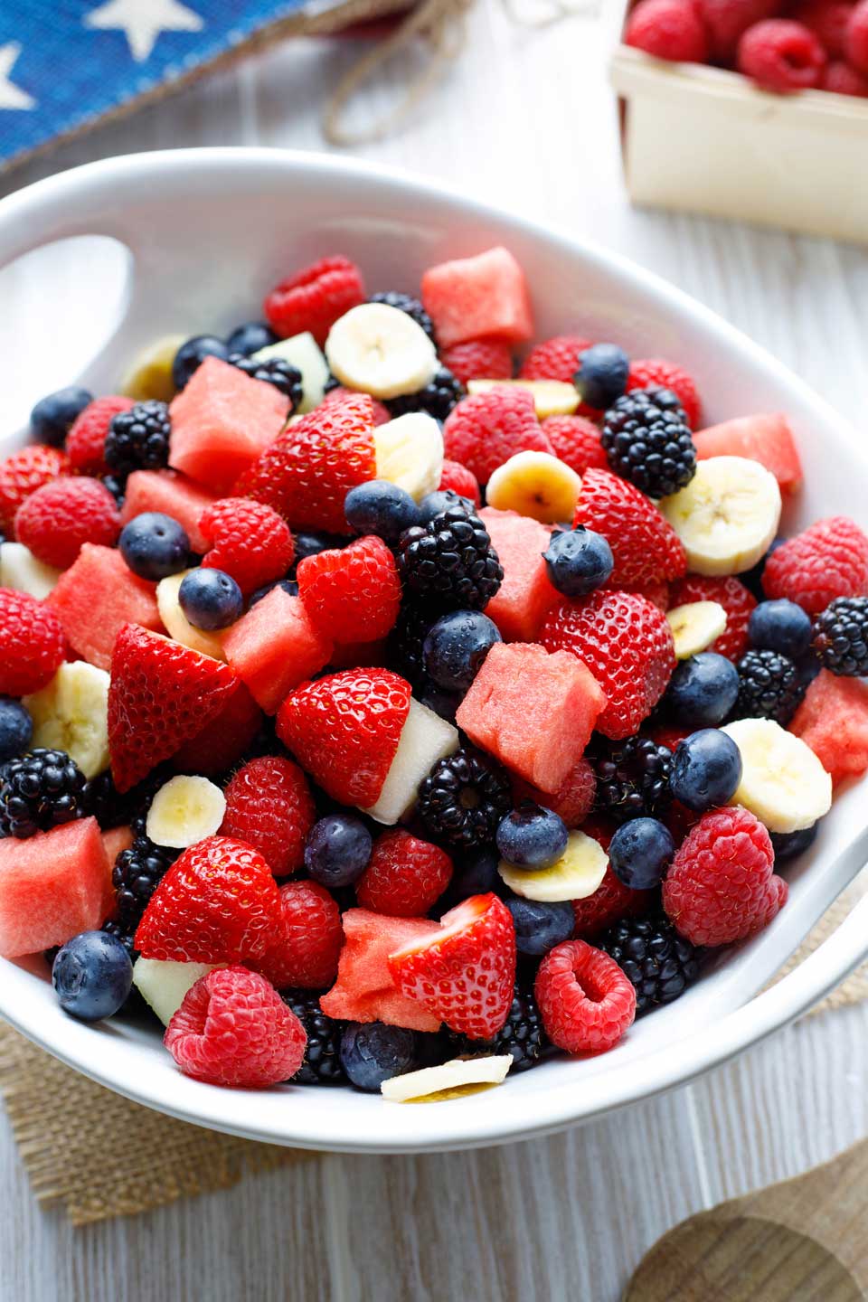 Large bowl filled with a mixture of red, white and blue fruits to show the easiest option for making a patriotic fruit salad