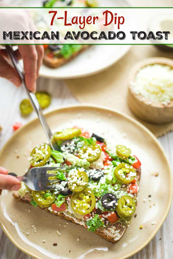 photo of a knife and fork cutting into a piece, with the text overlay 7-Layer Dip Mexican Avocado Toast