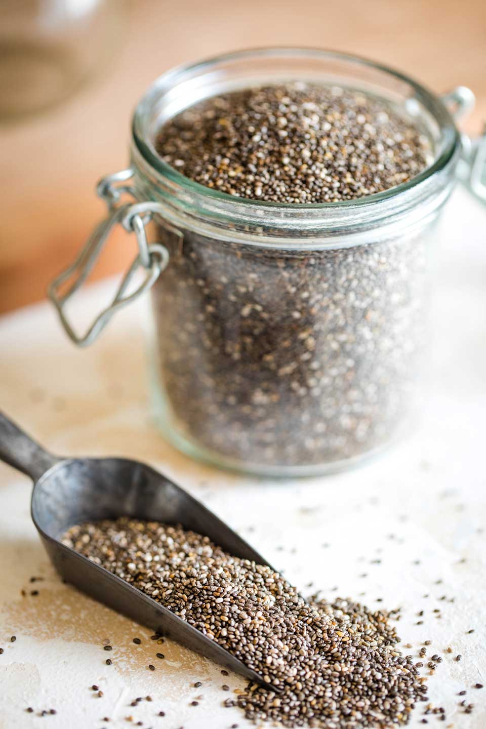 Jar of raw chia seeds and scoop full of seeds
