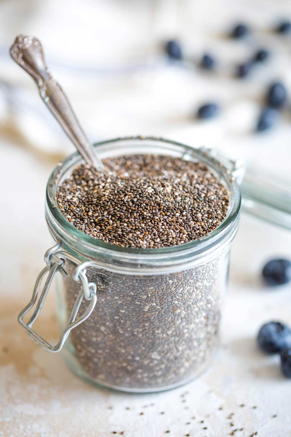 storage jar filled with chia seeds, with spoon in it