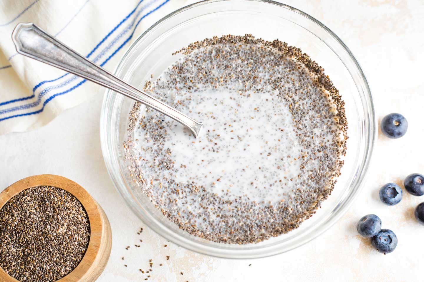 mixing bowl with chia seeds and coconut milk, just starting to be stirred together