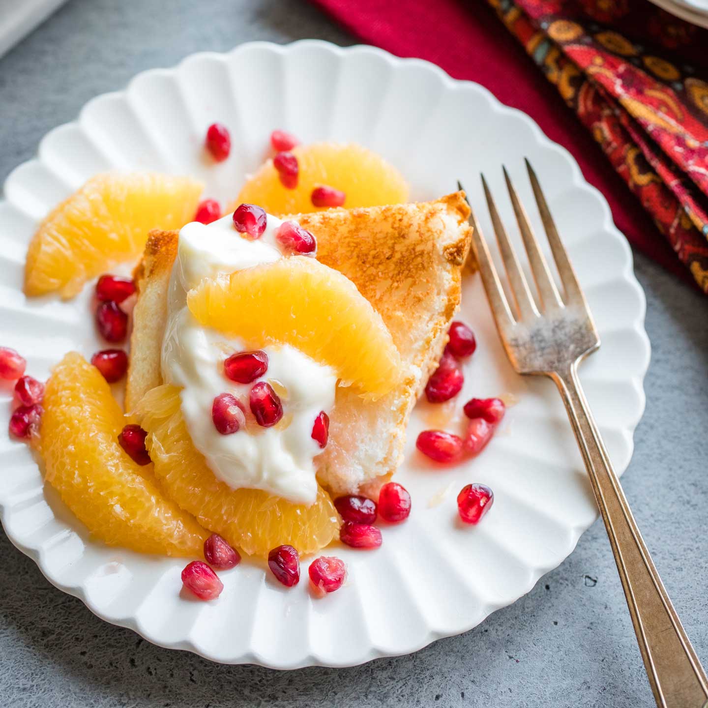 one serving of this dessert, served on a white, scalloped-edge plate with a golden fork