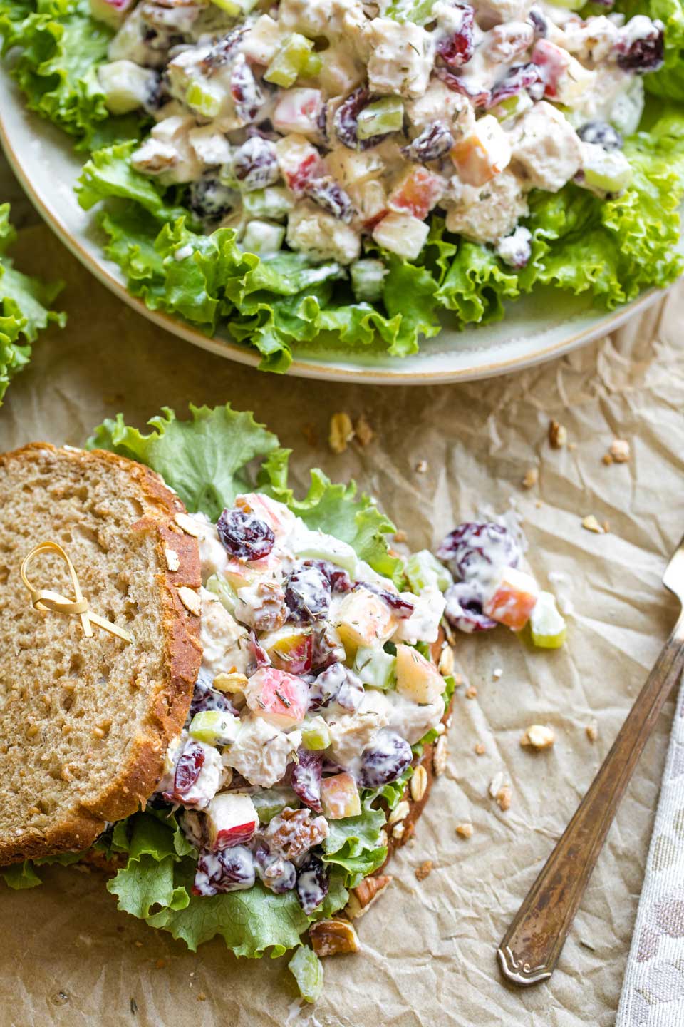 Overhead photo of two options of this turkey salad recipe served as a sandwich, and also plated as a salad on top of green, leafy lettuce.