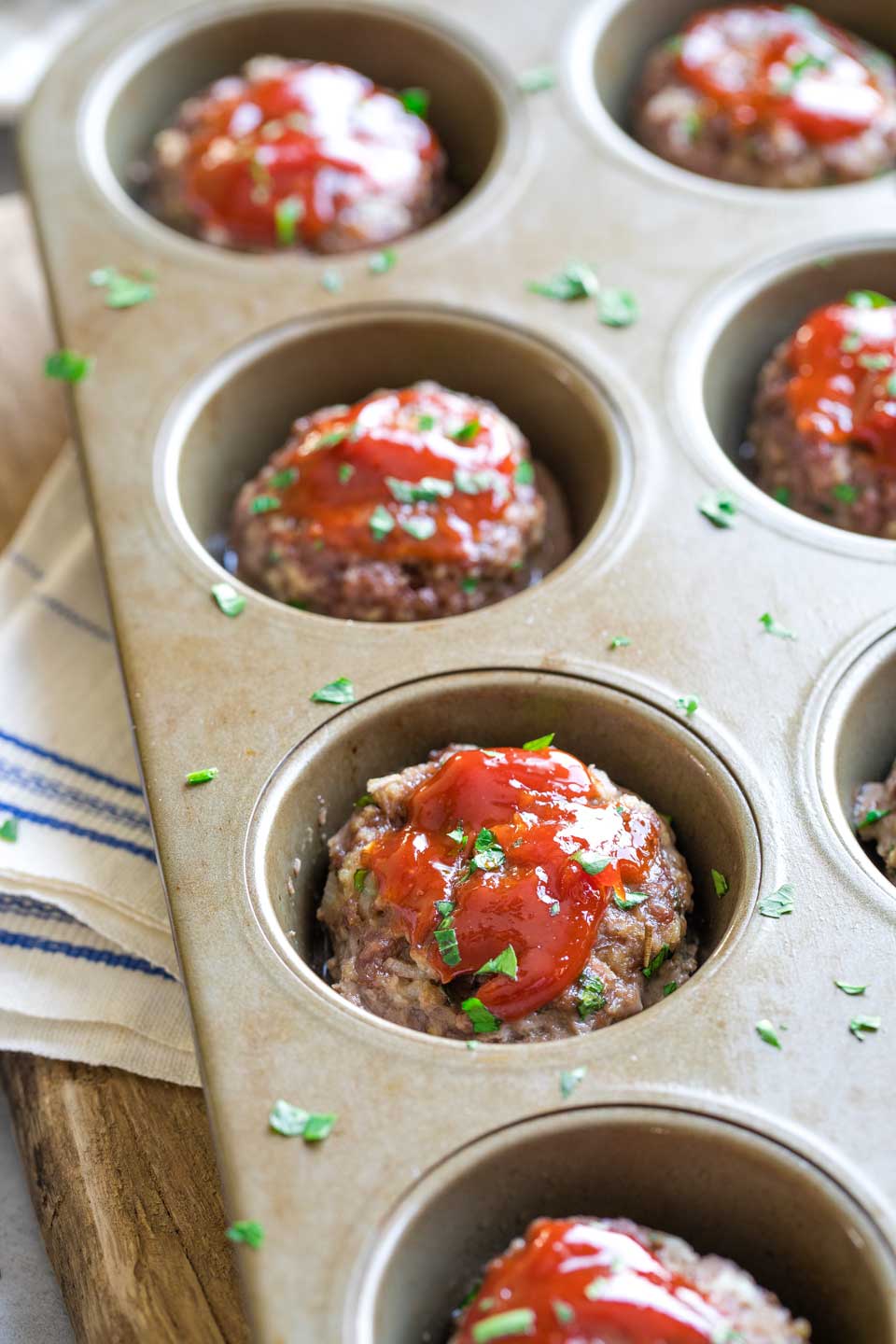 Closeup of a few meatloaf muffins, still in muffin tin after coming out of the oven.