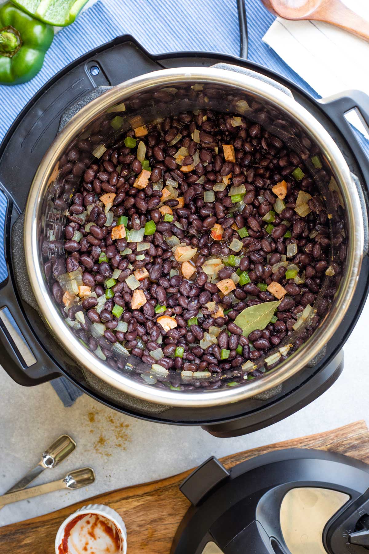 Black beans added to other soup ingredients in pressure cooker.