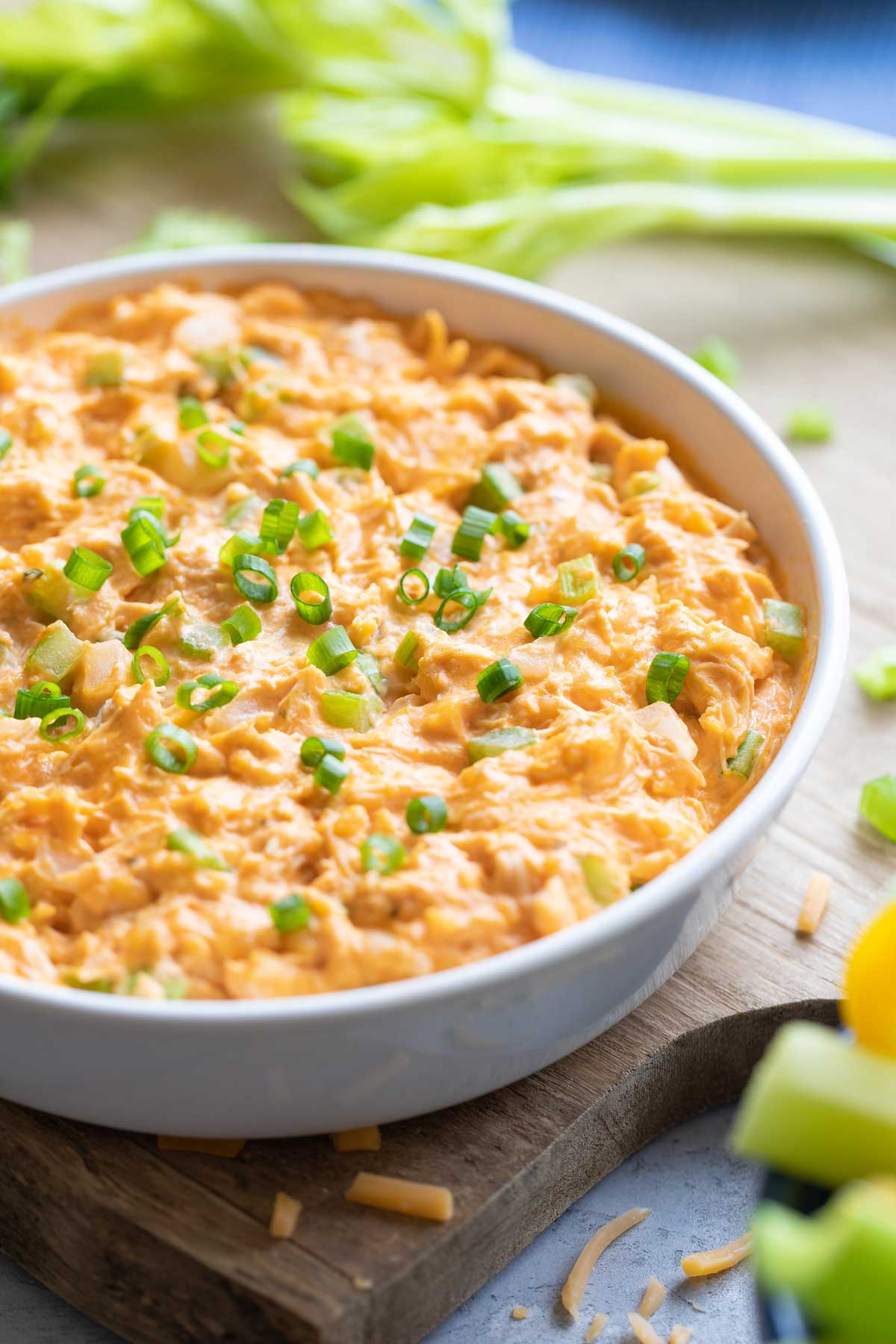 Finished bowl of Healthy Buffalo Chicken Dip on cutting board.