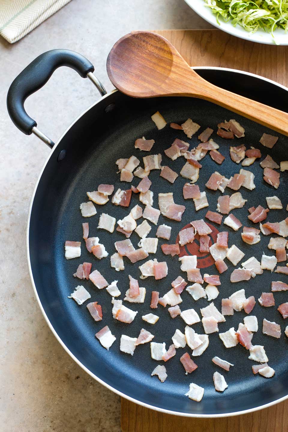 Diced bacon in pan before being sauteed.