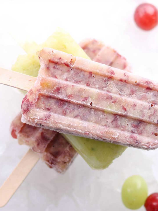 Frozen Grapes on a Stick Cover Image - Super closeup of a stack of frozen pops, with a red one on top.