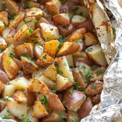 Grilled potatoes still in foil that's been opened.