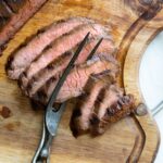 Several slices on wooden board with meat fork.