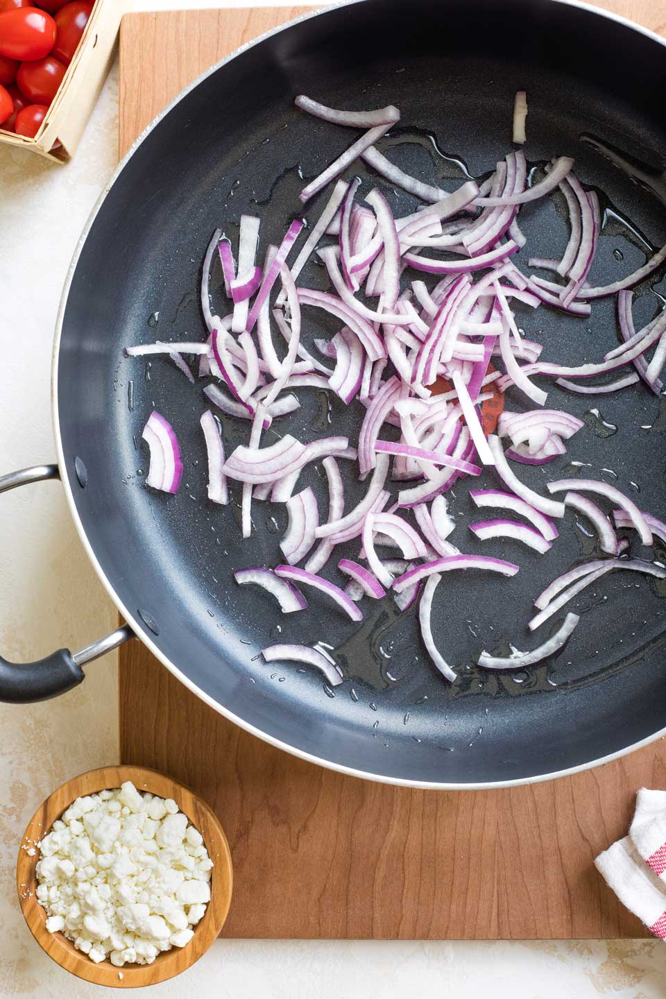 Overhead of raw onions added to skillet.