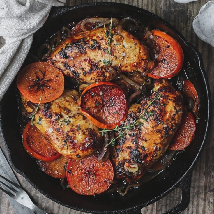 Overhead of final recipe in cast iron skillet on rustic gray wood table.