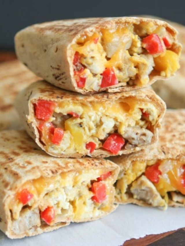 Several halved burritos stacked on top of each other on white parchment.