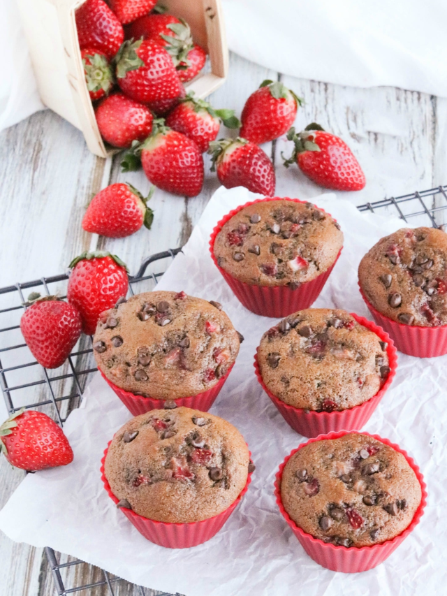 Baked muffins cooling on parchment-lined rack.