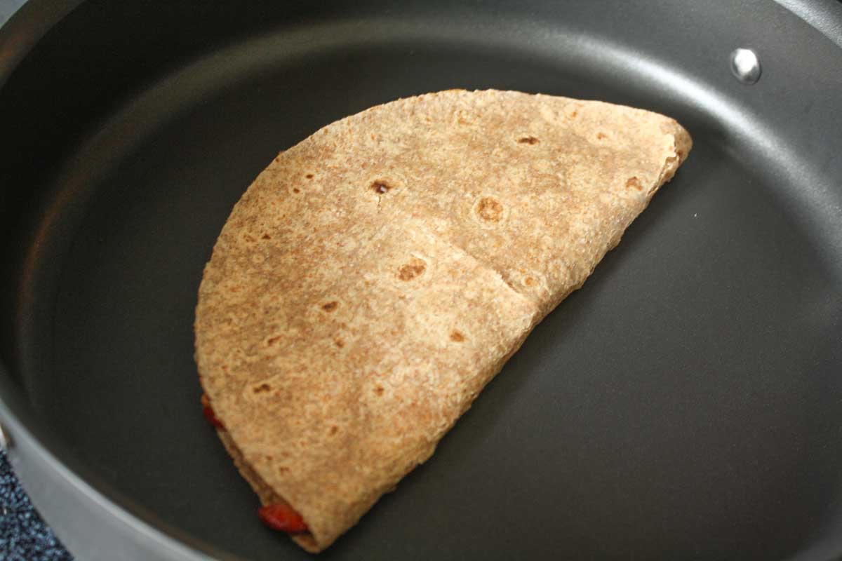 Tortilla grilled in pan, folded closed like quesadilla.
