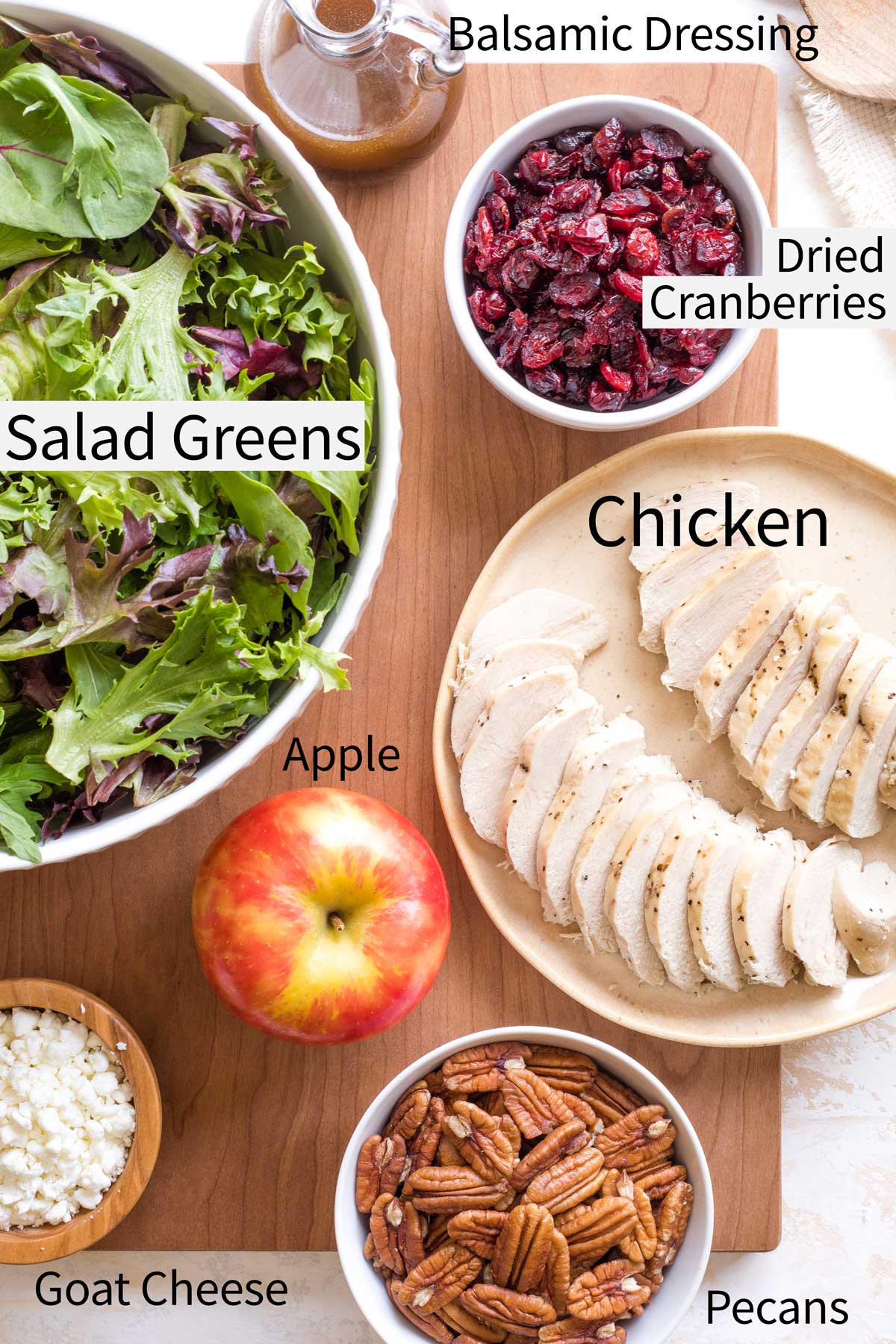 Flatlay of ingredients with labels: Salad Greens, Balsamic Dressing, Dried Cranberries, Chicken, Pecans, Apple, Goat Cheese.