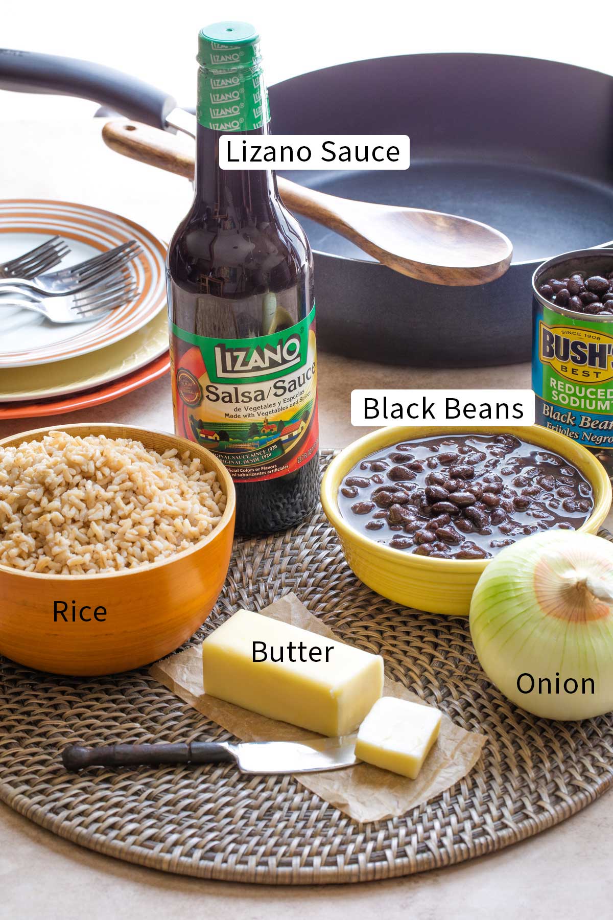 Labeled photo of recipe ingredients with text overlays "Lizano Sauce", "Rice", "Black Beans", "Butter" and "Onion".