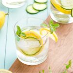 Closeup of one glassful, garnished with lemon slice and mint springs.