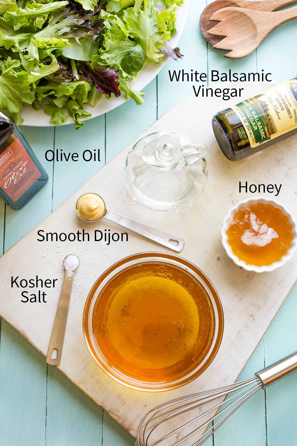 Vinaigrette ingredients on white cutting board with names labeled: Olive Oil, White Balsamic Vinegar, Honey, Kosher Salt, Smooth Dijon.