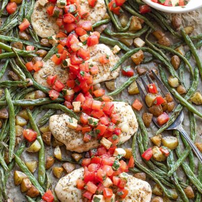 Overhead of full dinner still on baking pan with dish of extra topping.