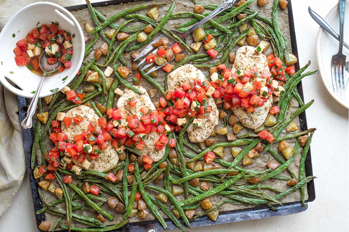 Overhead of finished recipe on 1 sheet pan with bowl of extra topping, ready to serve.