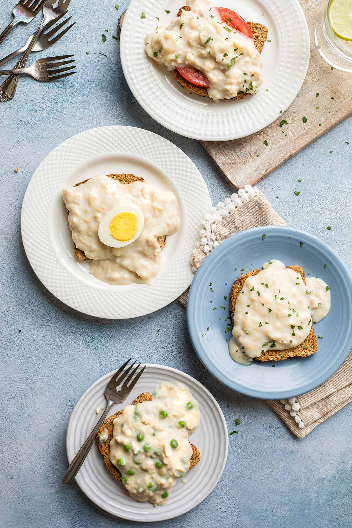 Overhead of the different recipe serving ideas, on different plate styles with napkin and forks.