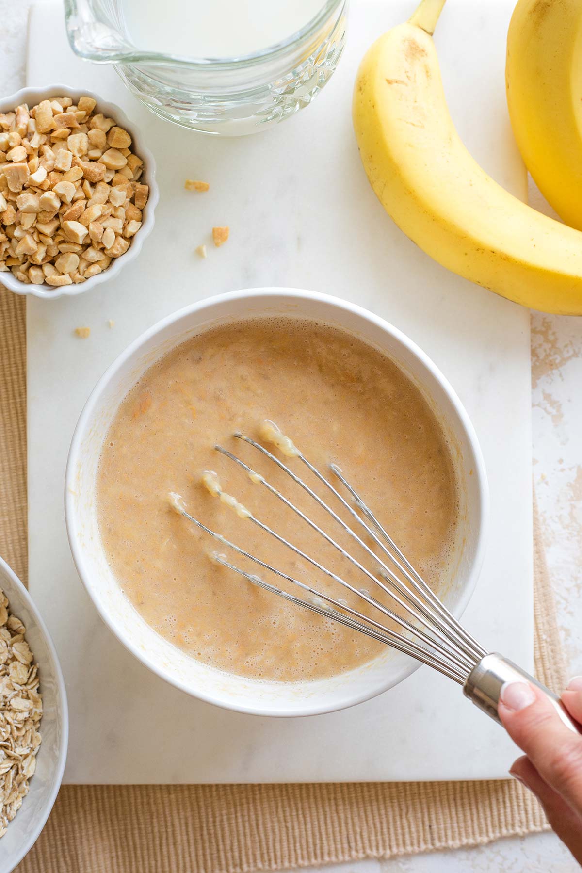 Hand using whisk to finish combining peanut butter mixture.