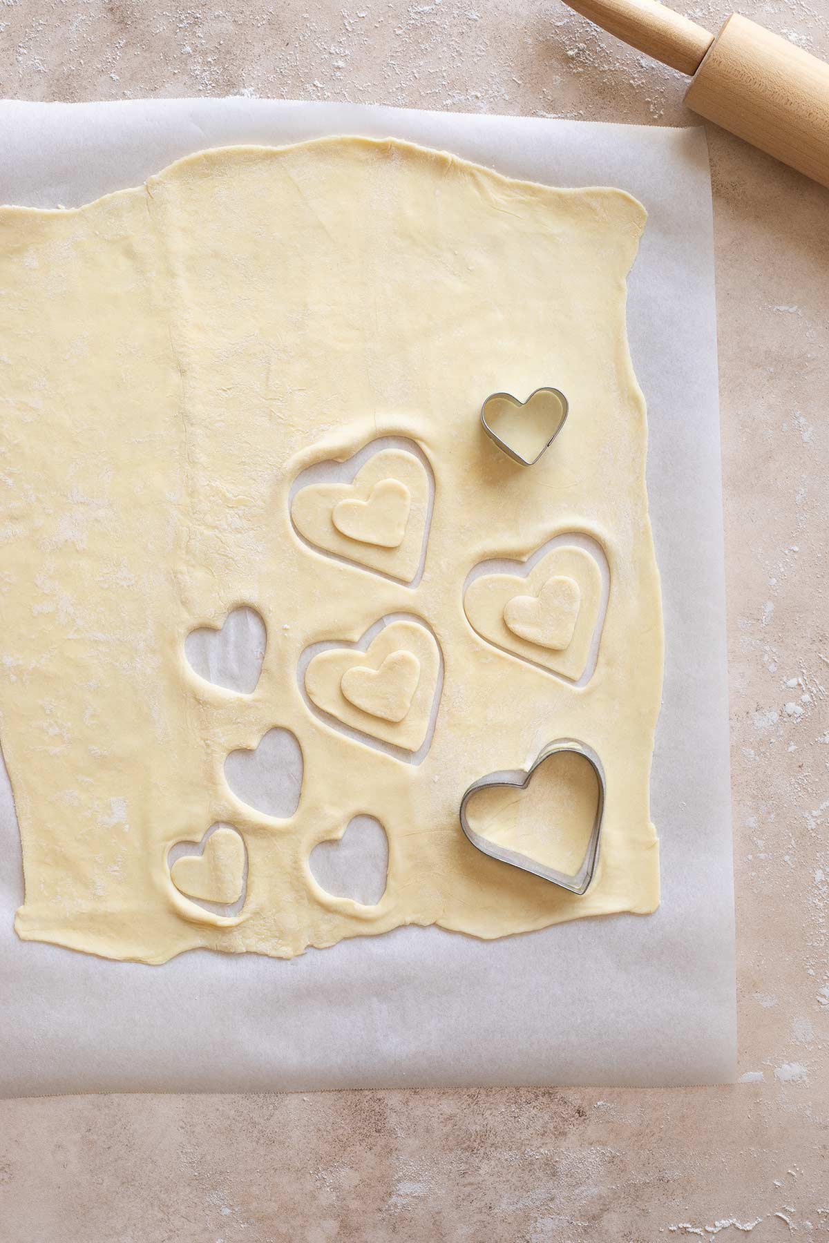 Heart-shaped cookie cutters cutting our p[uff pastry hearts to be used for Valentine's Day beef Wellingtons.