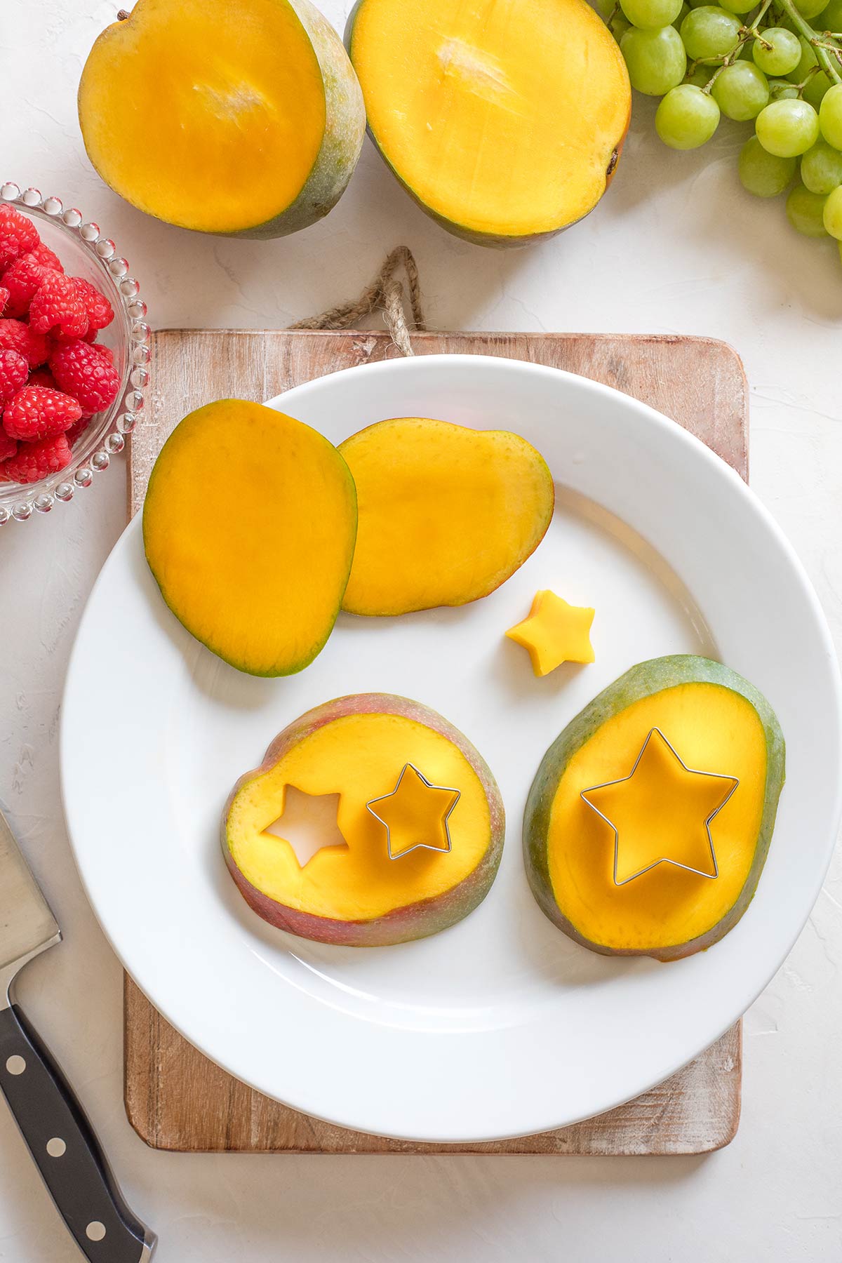 Star-shaped cookie cutters making stars out of mango slices.