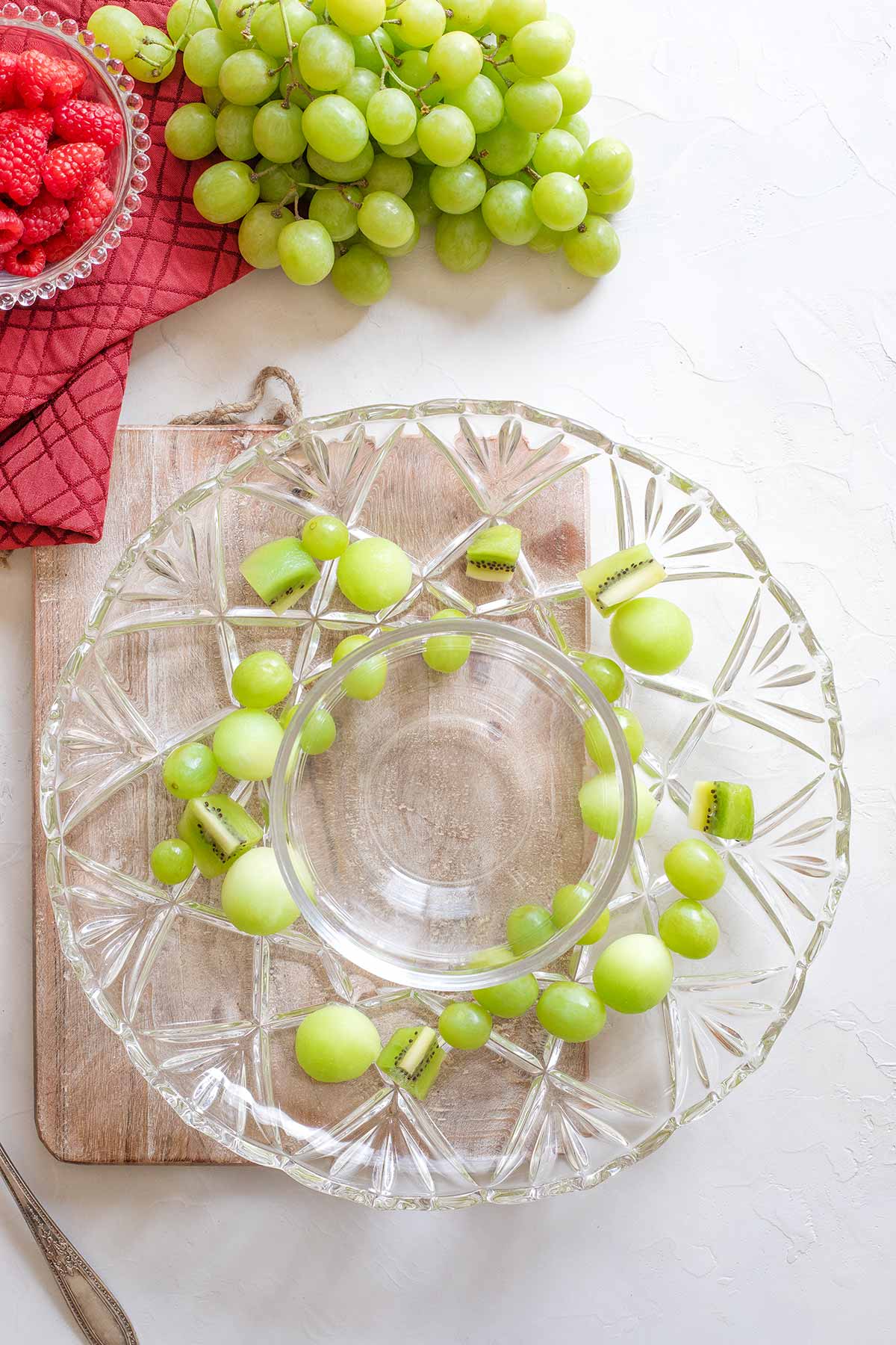 The first green fruits being placed into wreath shape on a glass platter.